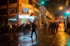La Paz, Bolivia. 7th Nov 2019. A protester defies supporters of Evo Morales by upholding the Bolivian flag. Surprisingly, a small Police unit started firing tear gas at supporters of Evo Morales Radoslaw Czajkowski